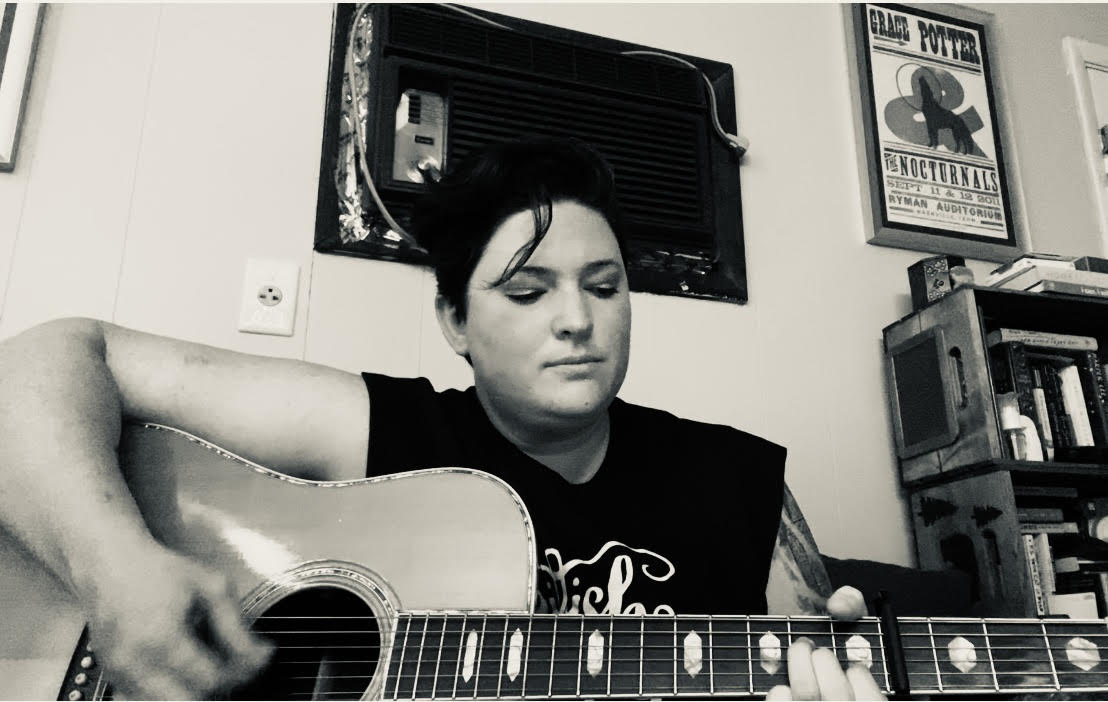 Jennifer playing guitar in her house studio